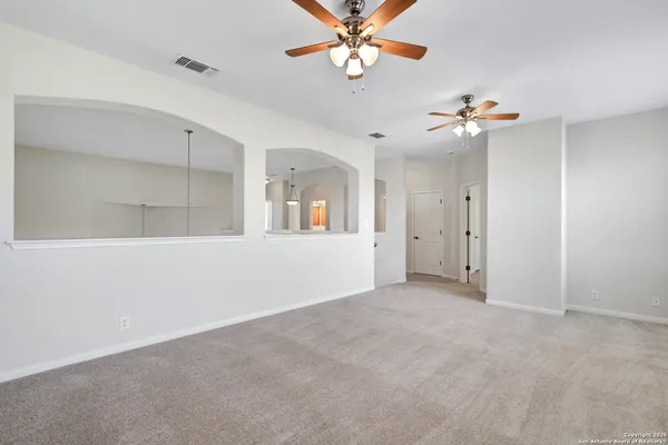 a view of an empty room with a ceiling fan