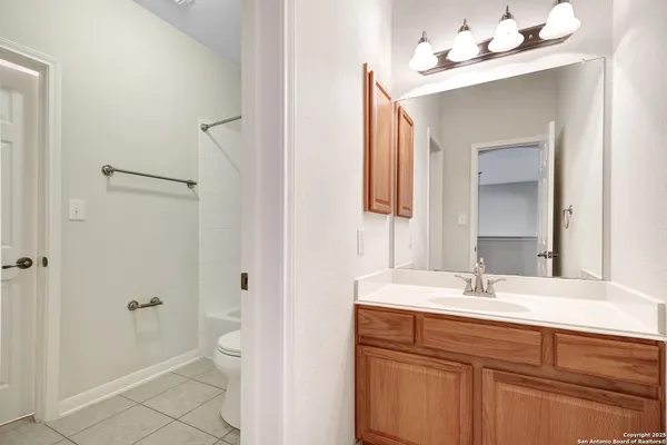 a bathroom with a sink vanity granite toilet and a mirror
