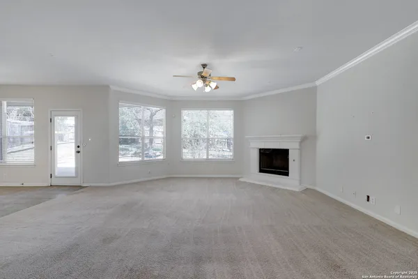 a view of an empty room with a fireplace and a window