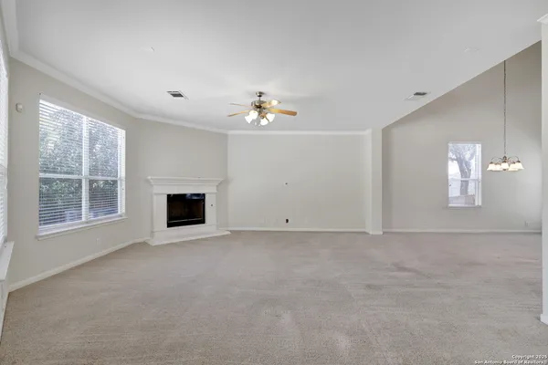 an empty room with windows and fireplace
