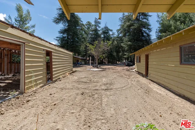 a backyard of a house with wooden fence and trees