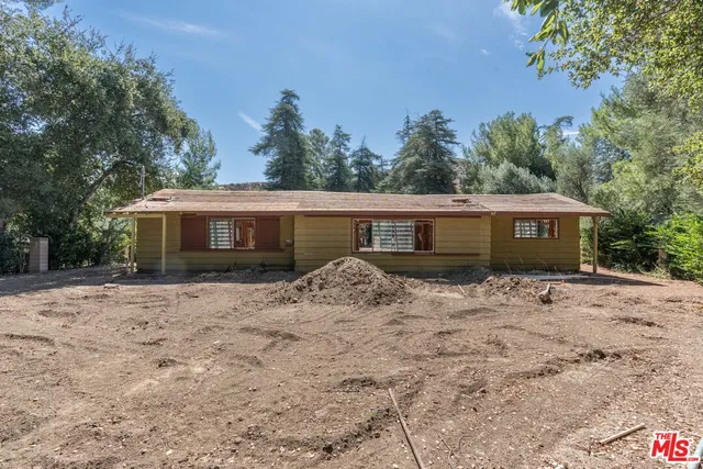 a view of a house with a yard and trees
