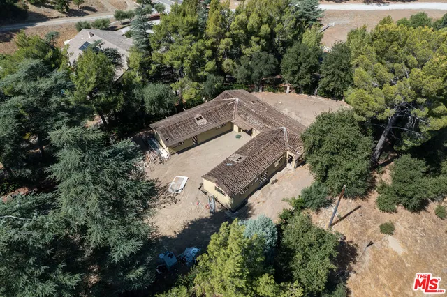 an aerial view of a house with a yard lake and outdoor seating