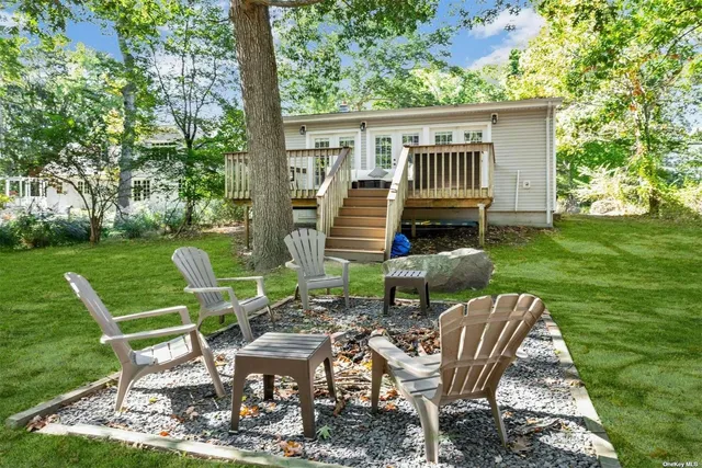a view of a chair and table in backyard of the house