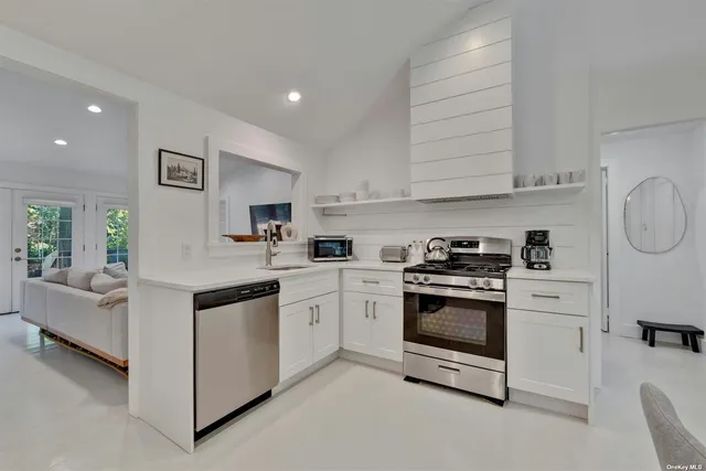 a kitchen with cabinets stainless steel appliances and a window