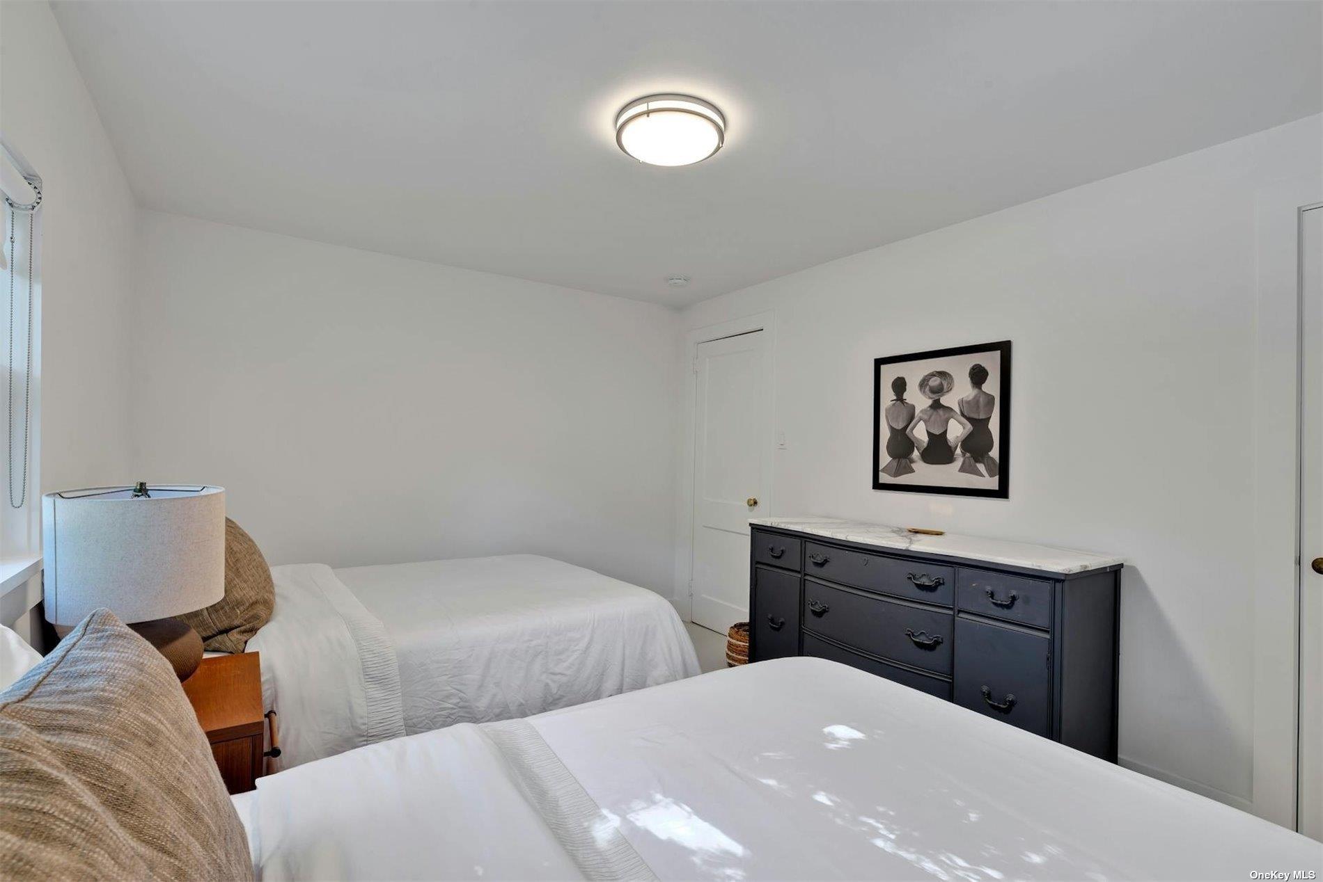 3670 Rocky Point Road East Marion, NY 11939 - Photo 9 of 26 a bedroom with two beds and a lamp