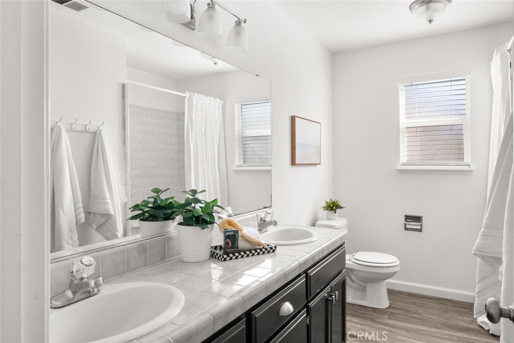 259 Picholine Way Chico, CA 95928 - Photo 29 of 38 a bathroom with a granite countertop sink toilet and a mirror