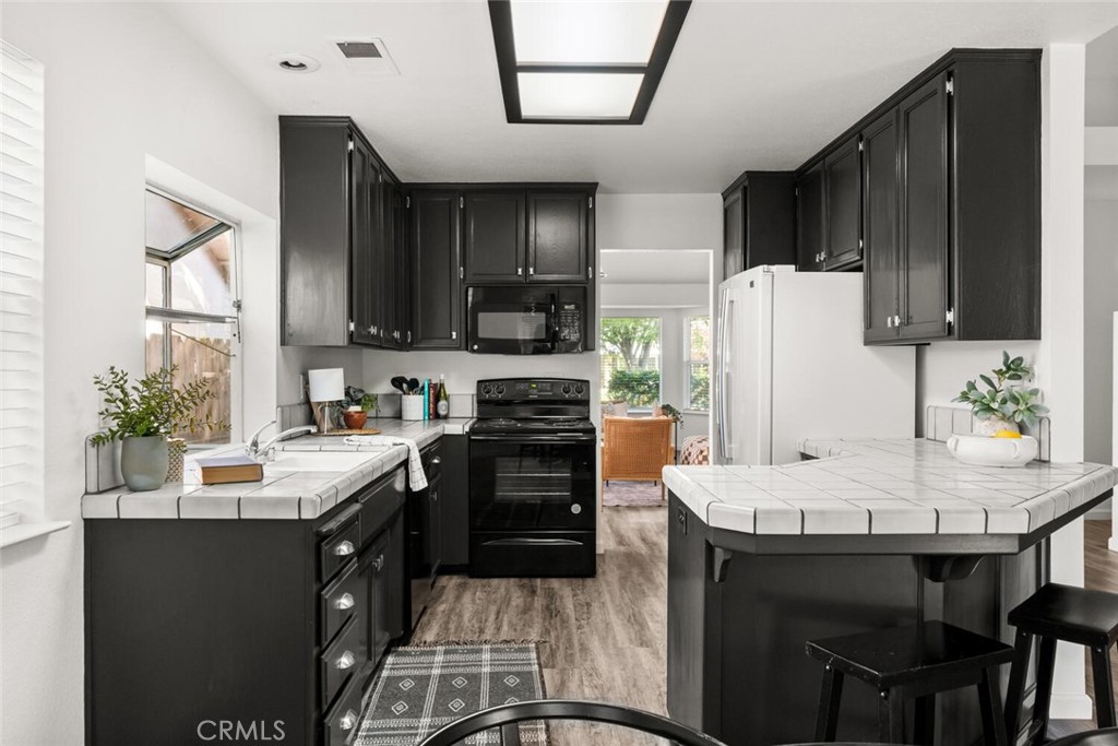 259 Picholine Way Chico, CA 95928 - Photo 6 of 38 a kitchen with a refrigerator a stove a sink a dining table and chairs