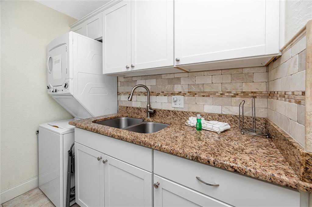 159 Medallion Boulevard, Unit F Madeira Beach, FL 33708 - Photo 20 of 47 a kitchen with granite countertop a sink and cabinets