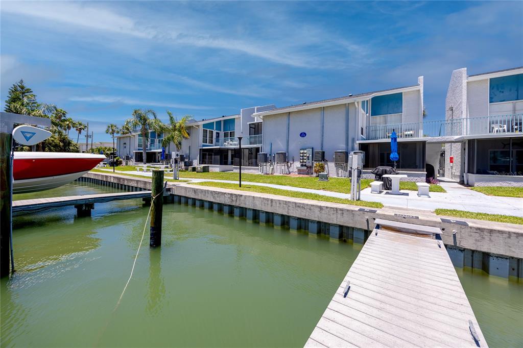 159 Medallion Boulevard, Unit F Madeira Beach, FL 33708 - Photo 2 of 47 a view of a swimming pool with a lounge chairs