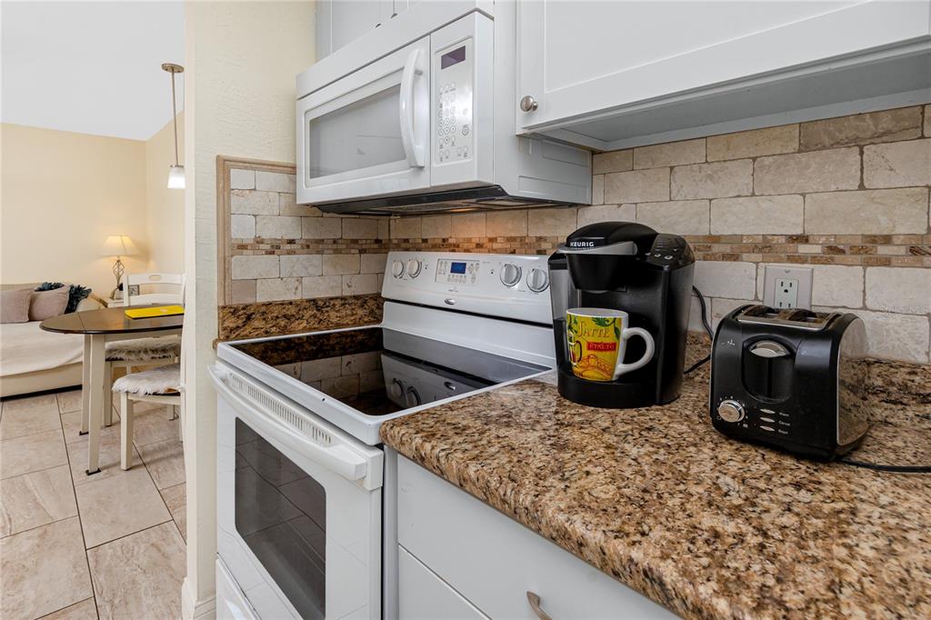 159 Medallion Boulevard, Unit F Madeira Beach, FL 33708 - Photo 23 of 47 a kitchen with a stove and a sink