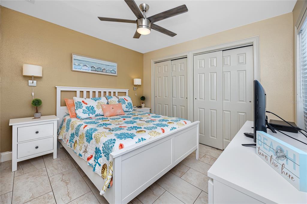 159 Medallion Boulevard, Unit F Madeira Beach, FL 33708 - Photo 24 of 47 a bedroom with a bed and a flat screen tv