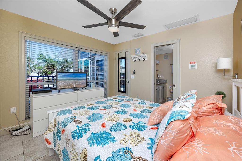 159 Medallion Boulevard, Unit F Madeira Beach, FL 33708 - Photo 25 of 47 a bedroom with a bed and a large window