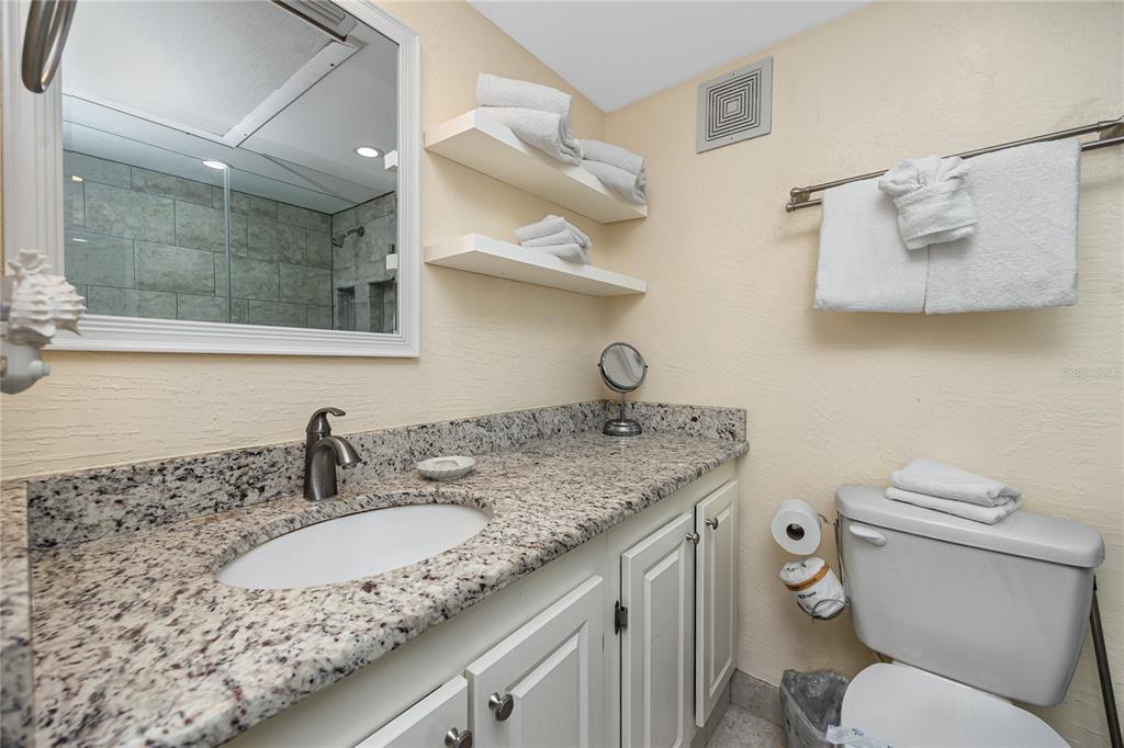 159 Medallion Boulevard, Unit F Madeira Beach, FL 33708 - Photo 28 of 47 a bathroom with a granite countertop toilet sink and mirror