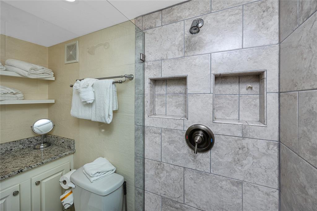 159 Medallion Boulevard, Unit F Madeira Beach, FL 33708 - Photo 30 of 47 a bathroom with a granite countertop toilet and a sink