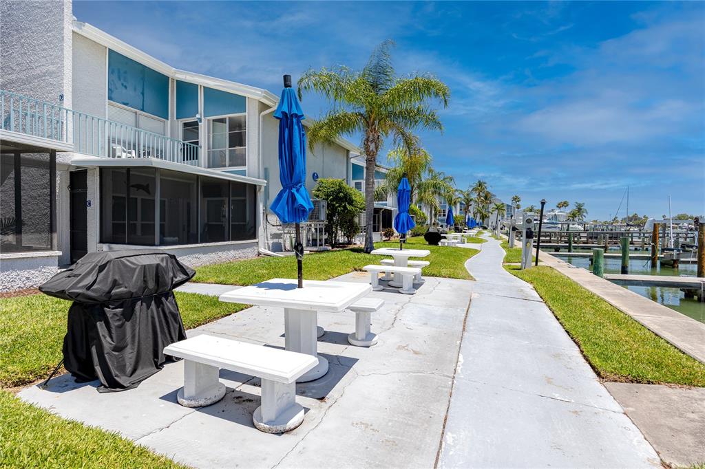 159 Medallion Boulevard, Unit F Madeira Beach, FL 33708 - Photo 33 of 47 a view of a fountain with a fire pit and chair in front of building