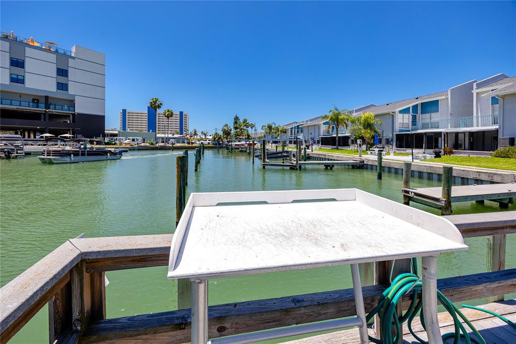 159 Medallion Boulevard, Unit F Madeira Beach, FL 33708 - Photo 35 of 47 a view of a lake with a table and chairs