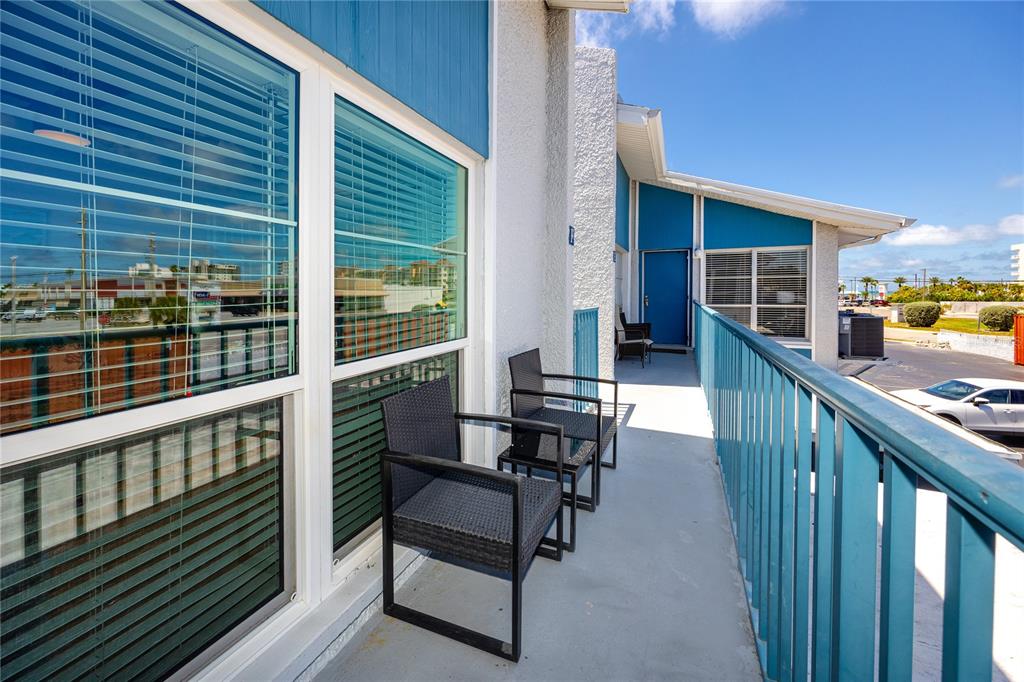 159 Medallion Boulevard, Unit F Madeira Beach, FL 33708 - Photo 5 of 47 a balcony with wooden floor outdoor seating and oven