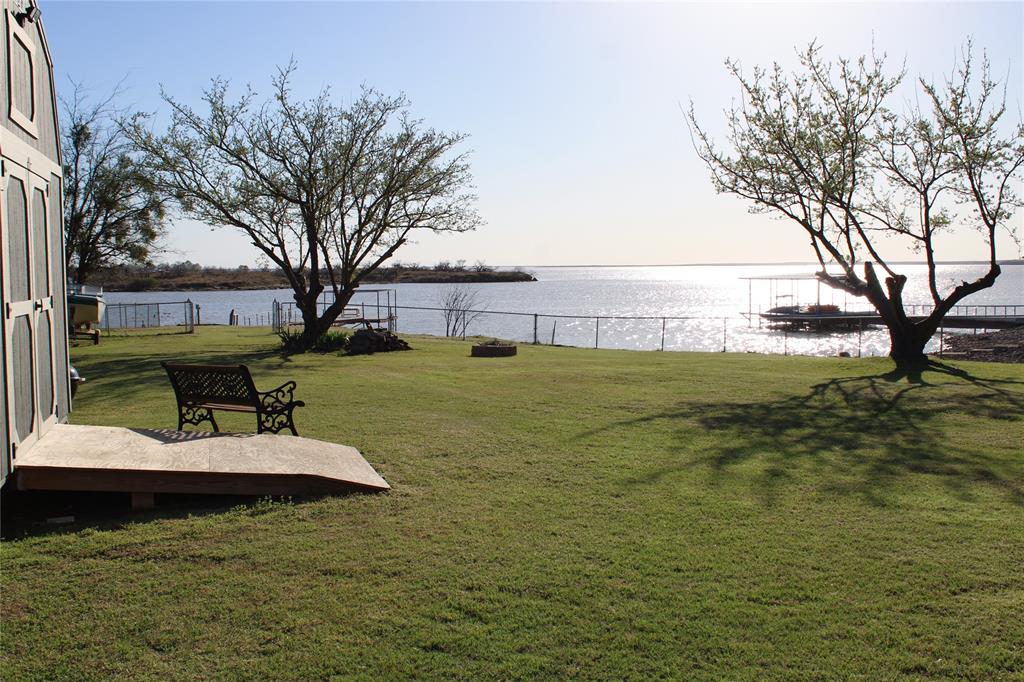 119 Seminole Trail Henrietta, TX 76365 - Photo 1 of 1 a view of a lake with a big yard and large trees