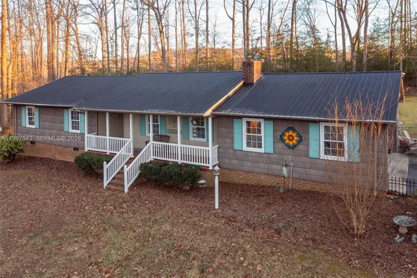 a backyard of a house with wooden fence and large trees