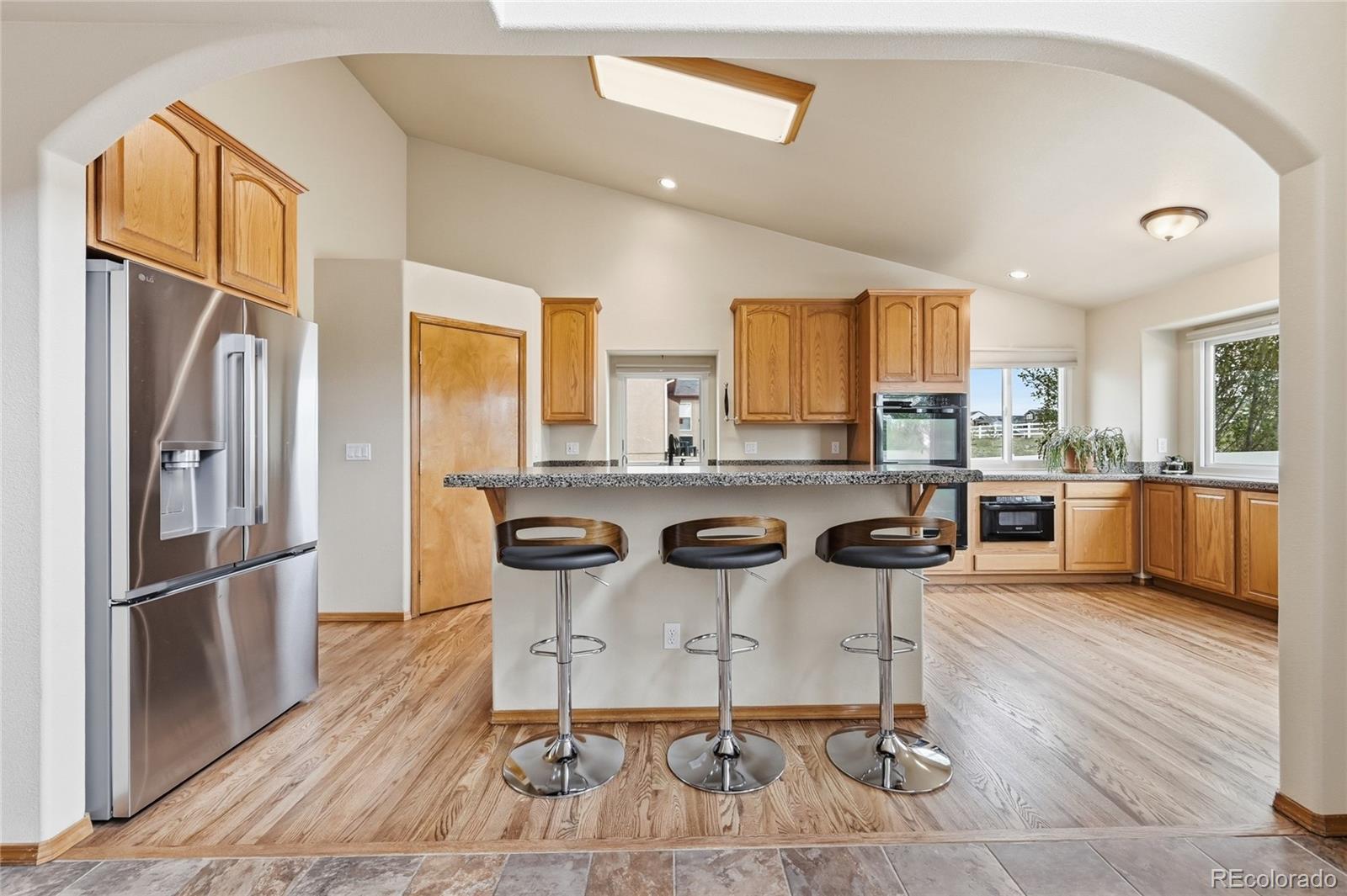 9288 Rockingham Drive Peyton, CO 80831 - Photo 11 of 49 a kitchen with a refrigerator a counter space dining table and chairs