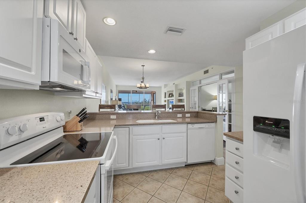 13313 Gasparilla Road, Unit 202 Placida, FL 33946 - Photo 17 of 57 a kitchen with white cabinets and sink
