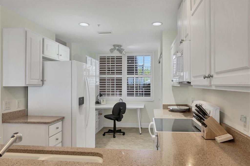 13313 Gasparilla Road, Unit C202 Placida, FL 33946 - Photo 17 of 49 a view of a kitchen with kitchen island stainless steel appliances wooden floor cabinets and a sink