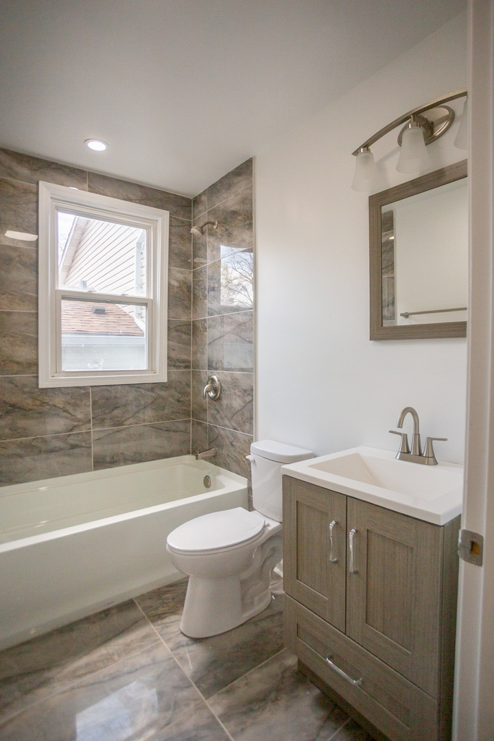 8810 South Morgan Street Chicago, IL 60620 - Photo 12 of 18 a bathroom with a sink toilet a mirror and bathtub