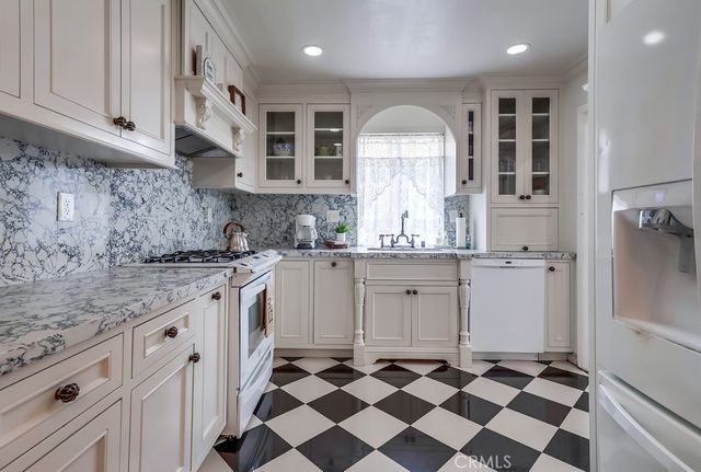 a kitchen with granite countertop appliances cabinets and a sink