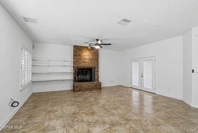 an empty room with wooden floor and natural light
