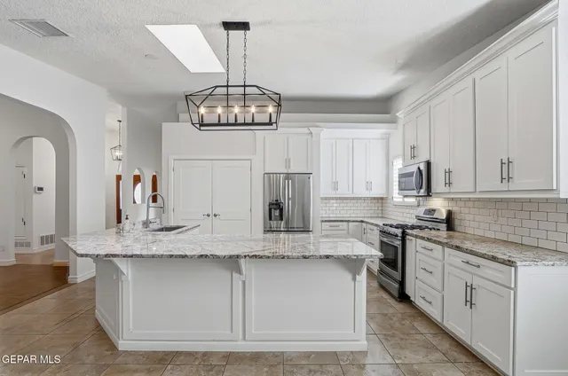 a bedroom with a bed a couch and potted plant with the potted plants