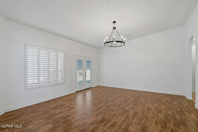 a kitchen with granite countertop white cabinets appliances and a window