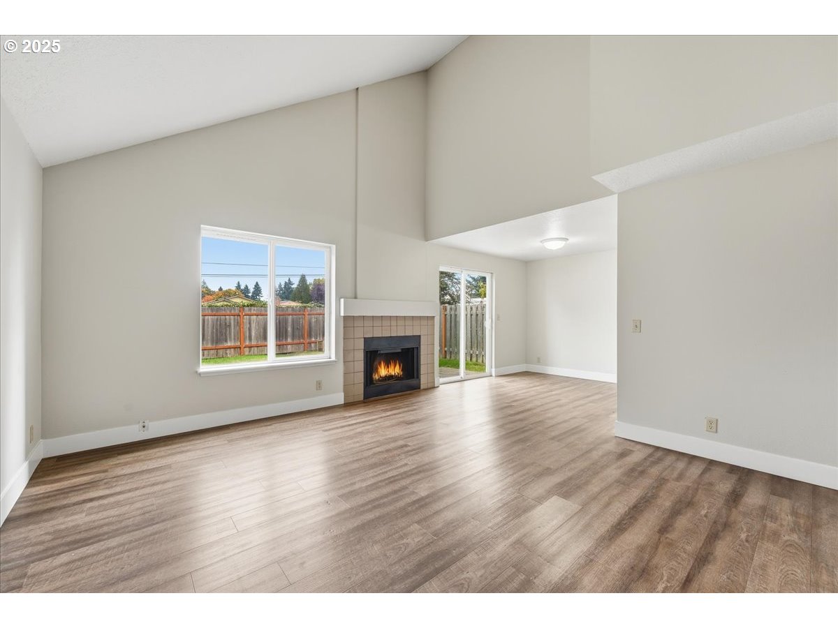5384 Southwest 186th Place Beaverton, OR 97078 - Photo 3 of 36 a view of an empty room with wooden floor fireplace and a window