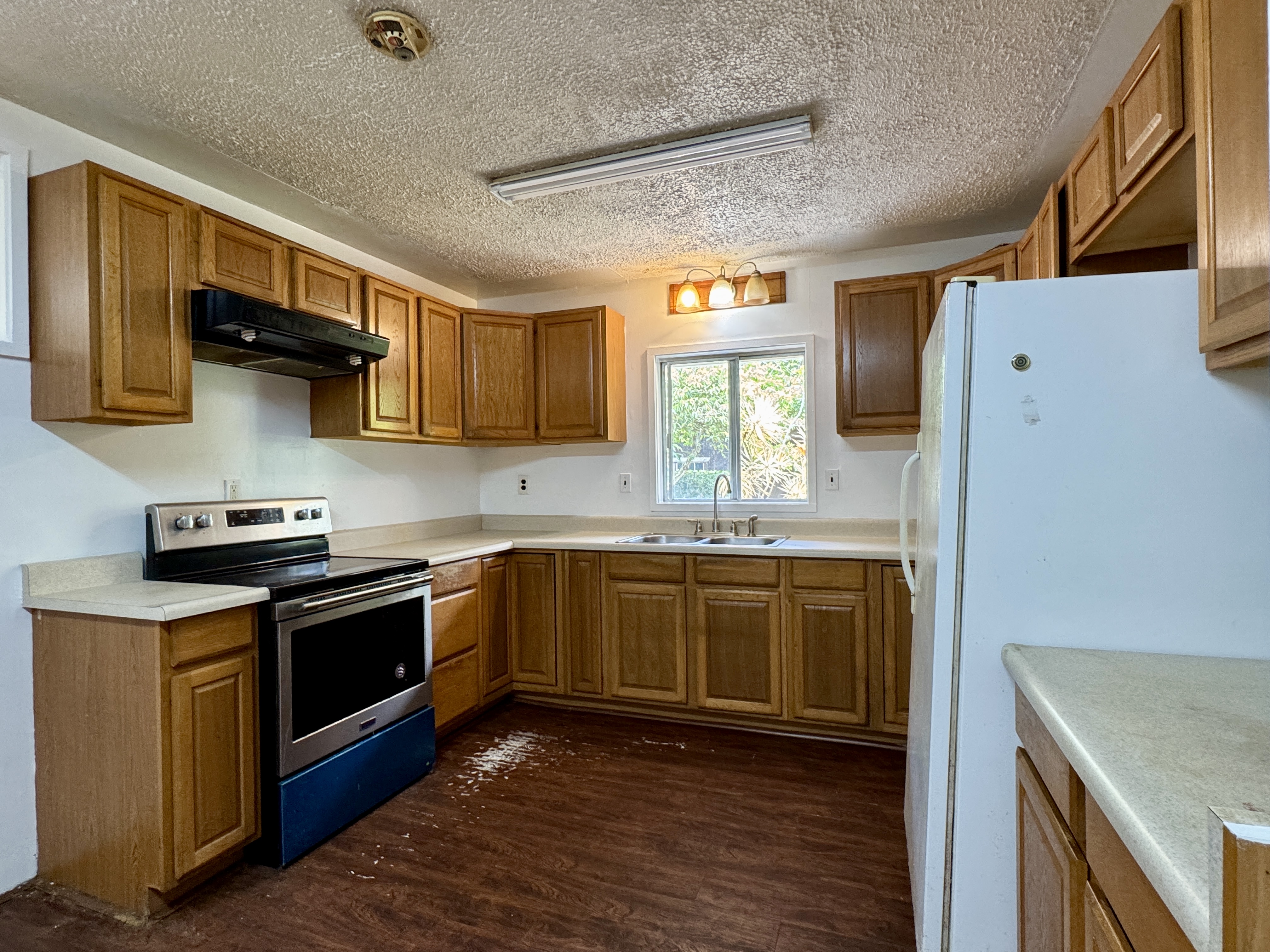 82-1226 Kinue Road Captain Cook, HI 96704 - Photo 5 of 28 a kitchen with stainless steel appliances granite countertop a stove a sink and a refrigerator