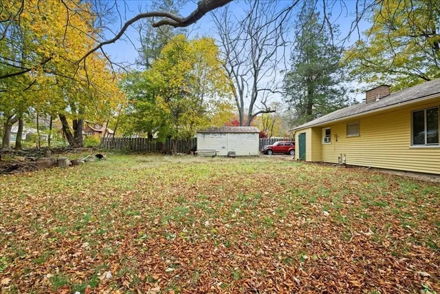 a front view of house with yard and trees around