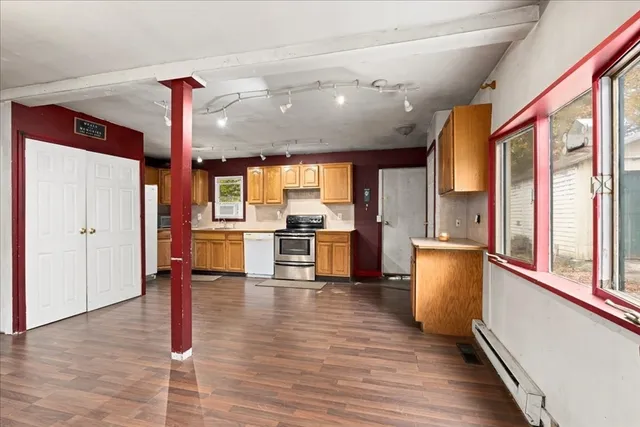 a large kitchen with stainless steel appliances granite countertop a stove and a refrigerator