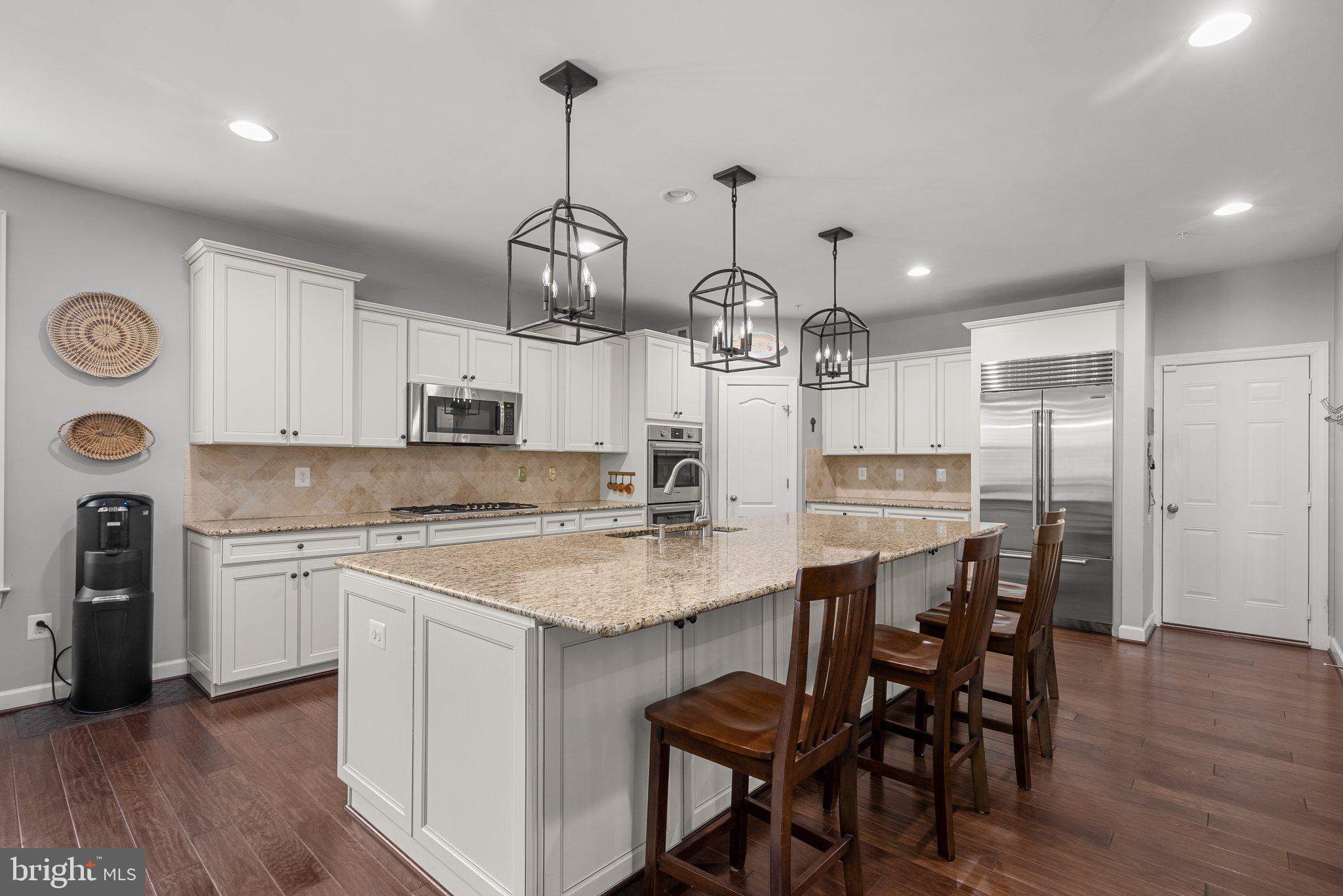 161 Moore Road Arnold, MD 21012 - Photo 15 of 57 a kitchen with stainless steel appliances a kitchen island a stove a table and chairs in it