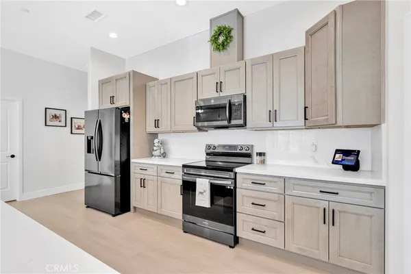 a kitchen with white cabinets and stainless steel appliances
