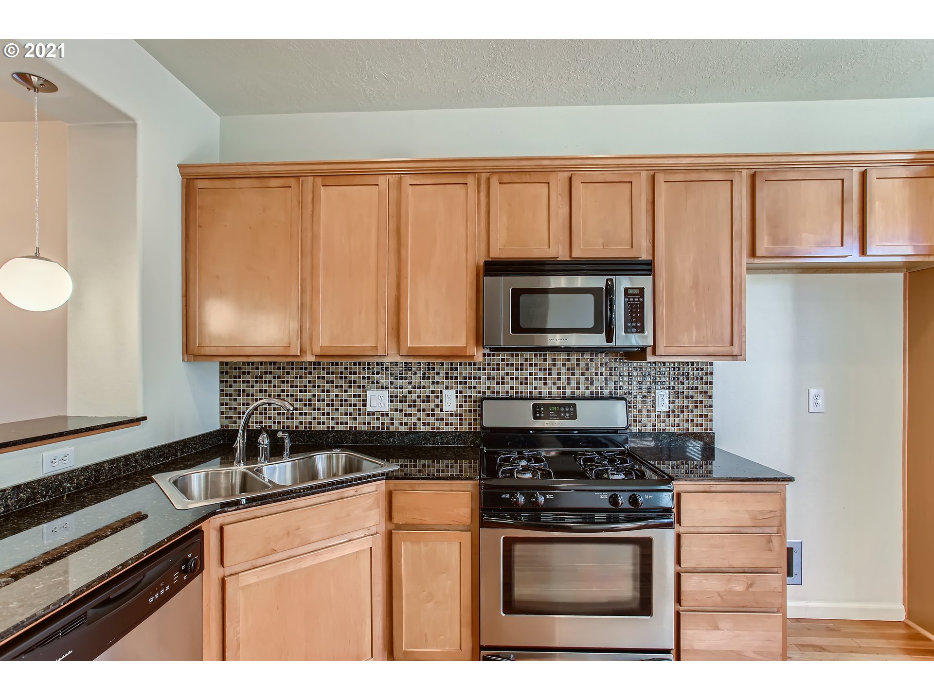 3621 Southwest Innovation Court Beaverton, OR 97003 - Photo 11 of 32 a kitchen with stainless steel appliances granite countertop a stove microwave and sink