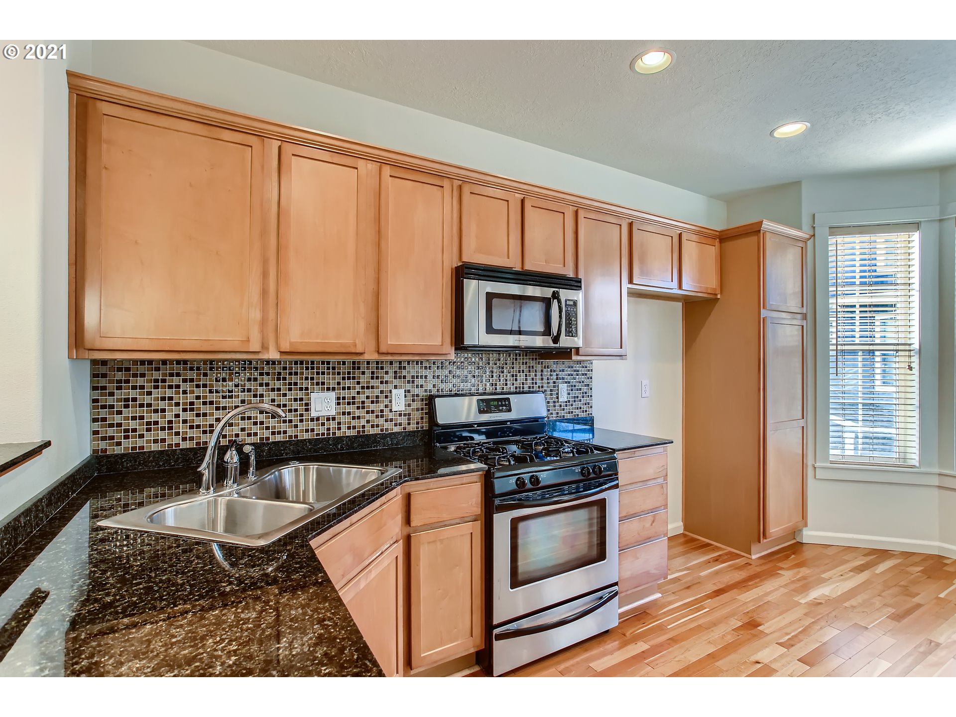 3621 Southwest Innovation Court Beaverton, OR 97003 - Photo 10 of 32 a kitchen with granite countertop a stove a sink and a microwave