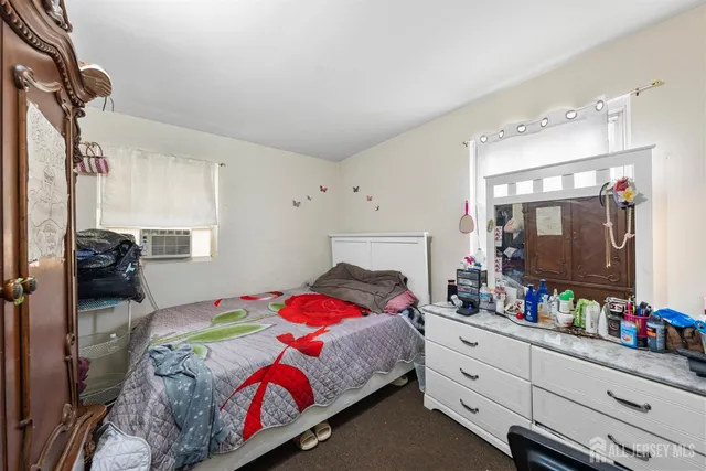 a bedroom with a bed and a dresser with the shoe rack