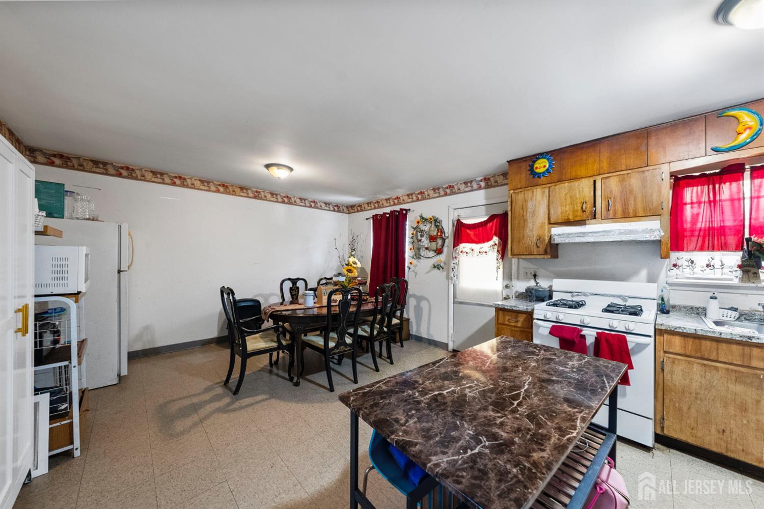 16 Millstone Road Somerset, NJ 08873 - Photo 24 of 35 a kitchen with stainless steel appliances granite countertop a stove top oven a dining table and chairs with wooden floor