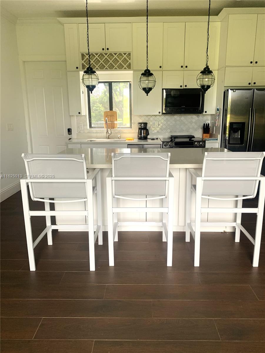 22750 Southwest 154th Avenue Miami, FL 33170 - Photo 14 of 37 a kitchen with stainless steel appliances kitchen island granite countertop a sink and cabinets
