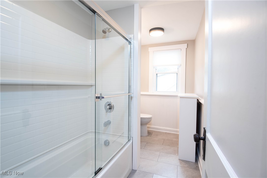 7003 Brecksville Road Independence, OH 44131 - Photo 13 of 35 Full bathroom featuring enclosed tub / shower combo, light tile patterned floors, and wainscoting