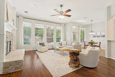 a living room with furniture large window and wooden floor