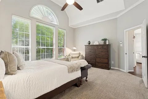 a bedroom with a bed a chandelier and a large window