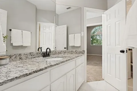 a bathroom with a granite countertop sink and a mirror