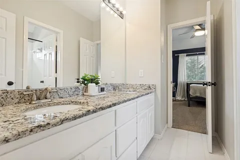 a bathroom with a granite countertop sink and a mirror