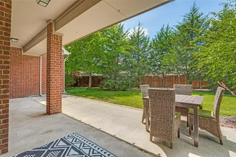 a view of a patio with a table and chairs