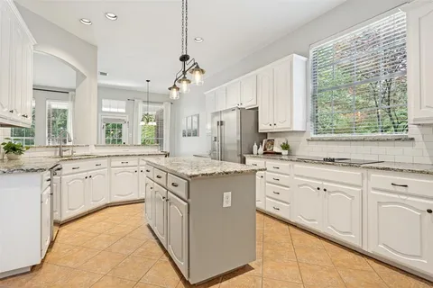 a kitchen with granite countertop white cabinets white appliances with a sink and dishwasher
